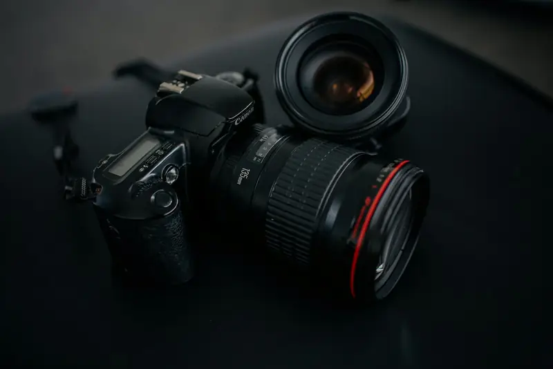 Camera body and lens on a dark surface