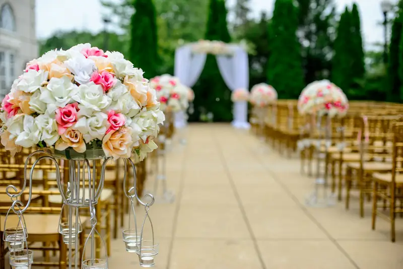 Outdoor wedding ceremony aisle lined with flowers