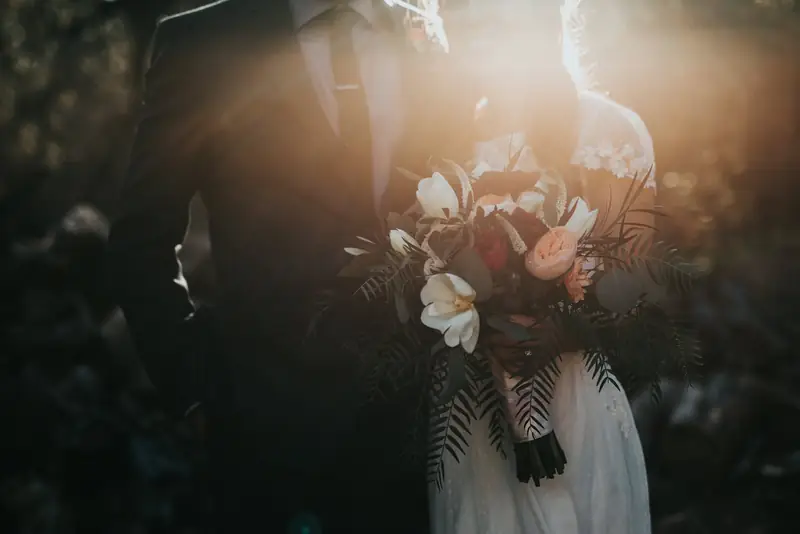 Bride holding a wildflower bouquet in warm evening light