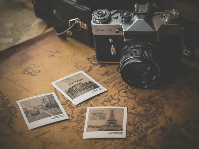 Vintage film camera with printed photographs on a map